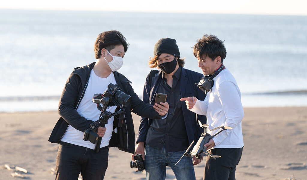海辺でオリジナルムービーを撮影しているクリエイター達