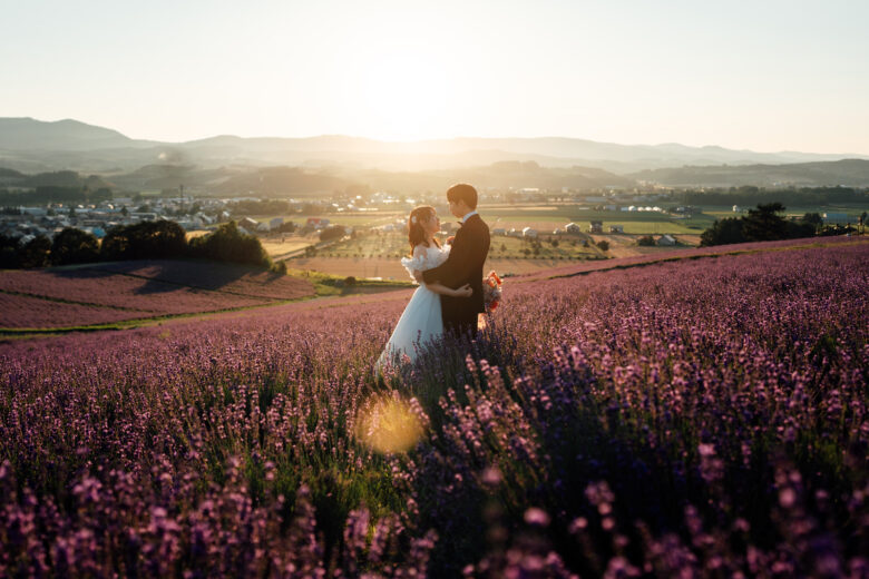 夕陽が差し込む富良野のラベンダー園で見つめ合う花嫁花婿さん